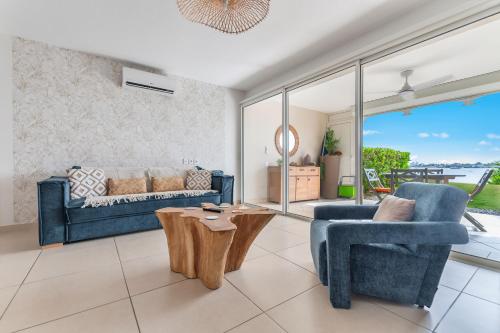 a living room with a couch and a chair and a table at Refait à neuf, magnifique vue sur le lagon appartement 4 à 5p in Marigot