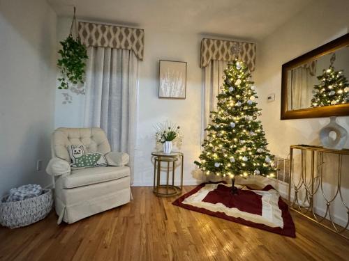 a living room with a christmas tree and a chair at Private 1st floor Apartment - Only 5 min Away from Newark Airport and 30 min to NYC in Elizabeth