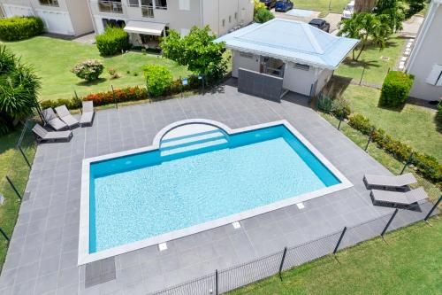 an overhead view of a swimming pool in a yard at Refait à neuf, magnifique vue sur le lagon appartement 4 à 5p in Marigot