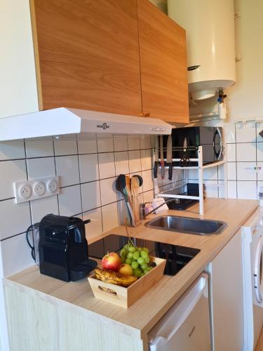 a kitchen with a box of fruit on a counter at Proche métro B et Hopital Lyon sud in Pierre-Bénite