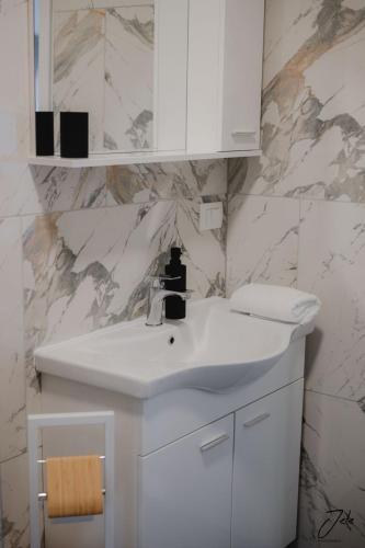 a white bathroom with a sink and a mirror at Apartment Angie in Lastovo