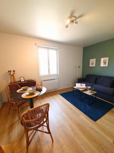 a living room with a blue couch and a table at Proche métro B et Hopital Lyon sud in Pierre-Bénite