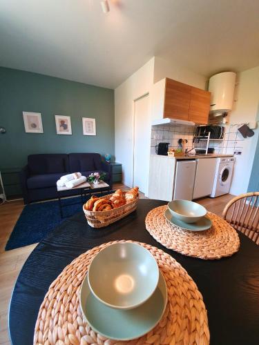 a living room with a table with plates and bread at Proche métro B et Hopital Lyon sud in Pierre-Bénite