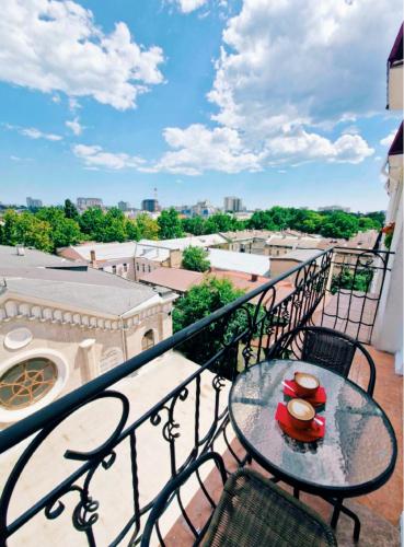 a table on a balcony with a view of a city at Boutique Hotel California in Odesa