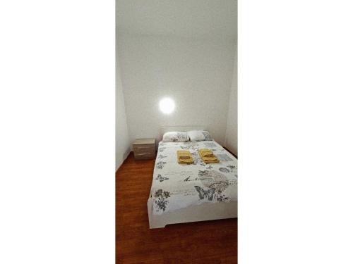 a small bedroom with a bed and a light on the wall at Apartment with two rooms and shared bathroom in Minusio