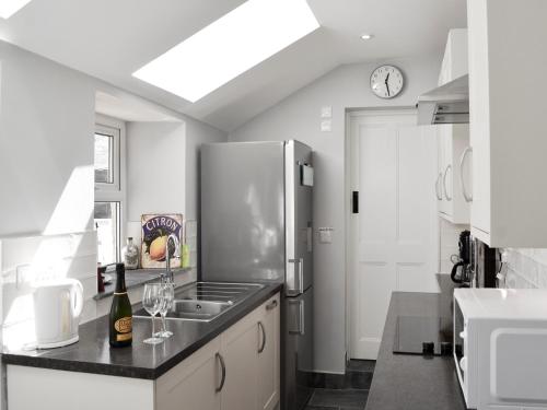 a kitchen with a stainless steel refrigerator and a sink at Morvoren in Lizard