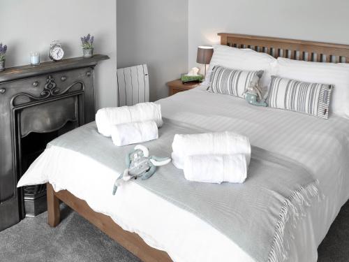 a bedroom with a large bed with towels on it at Morvoren in Lizard