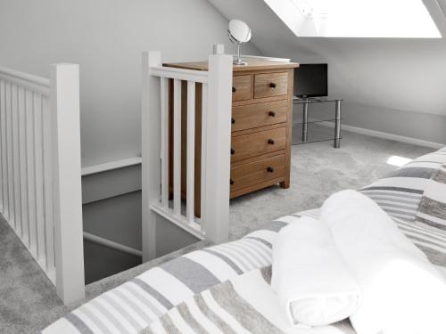 a bedroom with a bed and a wooden dresser at Morvoren in Lizard