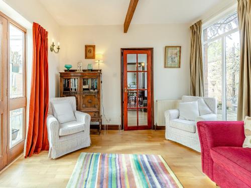 a living room with two chairs and a rug at The Coach House in Aldington