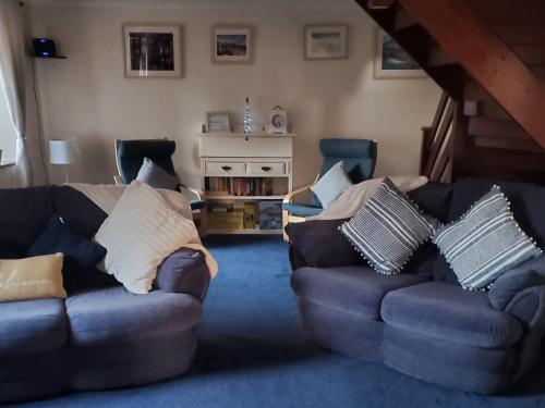 ein Wohnzimmer mit 2 Sofas mit Kissen in der Unterkunft Portland Cottage in Mousehole