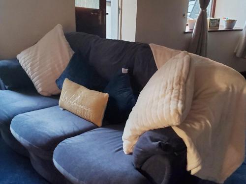 a blue couch with a blanket on it at Portland Cottage in Mousehole