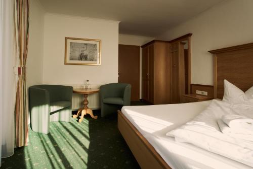 卡普伦Hotel Martini Kaprun - including summercard & breakfast的一间带床、桌椅的酒店房间