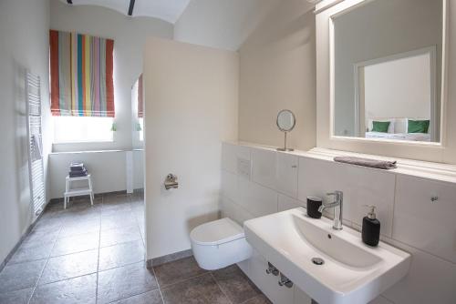 a white bathroom with a sink and a toilet at Storchenhof Blumenow in Blumenow