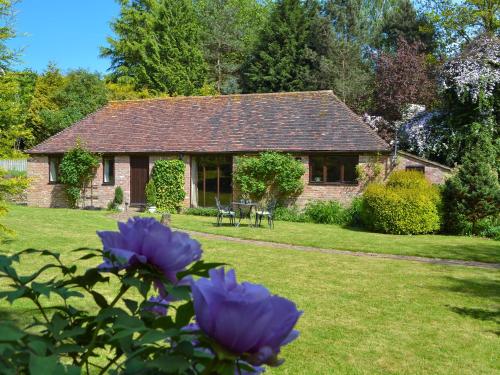 a cottage with purple flowers in front of it at Ivy Cottage in Sandhurst