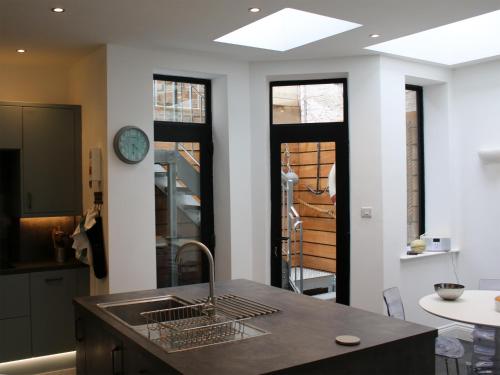 a kitchen with a sink and a clock on the wall at Bay House in Hastings