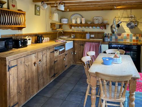a kitchen with a table and some chairs in it at Finkle Barn in Fryup