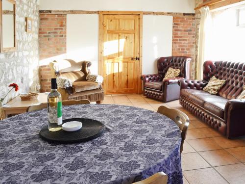 a living room with a table with a bottle of wine at Guillemot Cottage in Flamborough