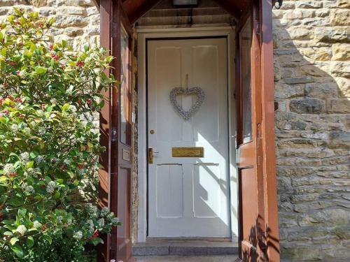 a door with a heart shaped wreath on it at Squirrel Cottage in Thornton Dale