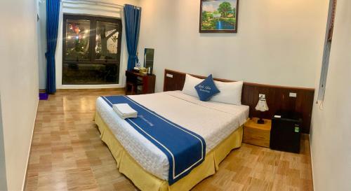 a bedroom with a large bed with blue and white sheets at Tam Coc Minh Gia Homestay in Ninh Binh