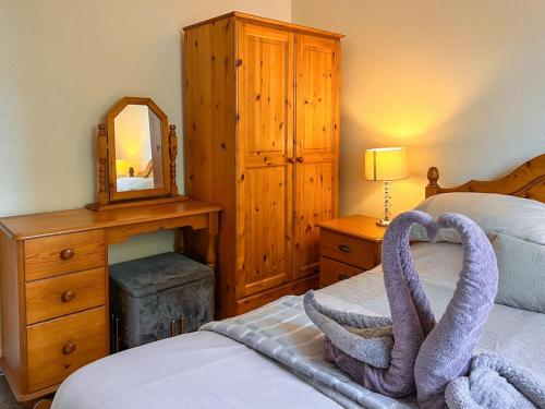 a bedroom with a bed with a heart shaped towel on it at Lilac Studio in Wheldrake