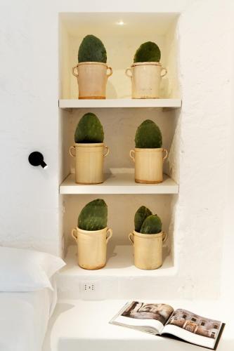 a shelf with five watermelons in buckets on it at Corte Manfredi in Alessano