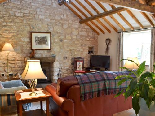 ein Wohnzimmer mit einer Couch und einer Steinwand in der Unterkunft Ash Garth Cottage in Kirby Misperton