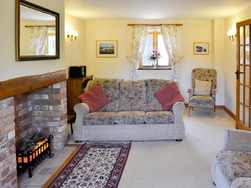 a living room with a couch and a fireplace at Carters Cottage in Puncknowle