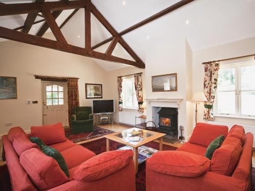 a living room with red couches and a fireplace at Ware House Cottage in Lyme Regis