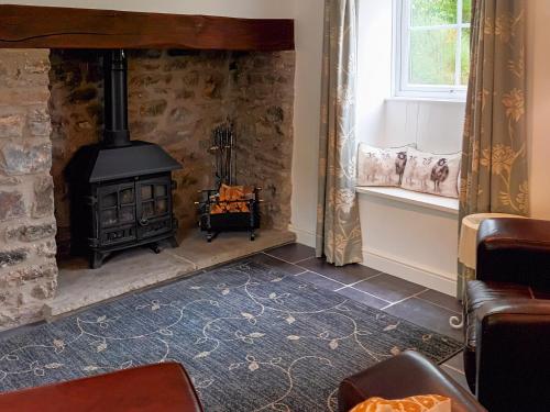 a fireplace in a living room with a stove at Honeymead Cottage in Wick