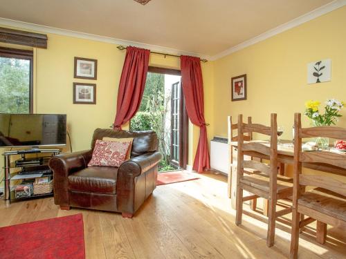 sala de estar con silla de cuero y TV en Ted 'N' Betty's, en Buckfastleigh