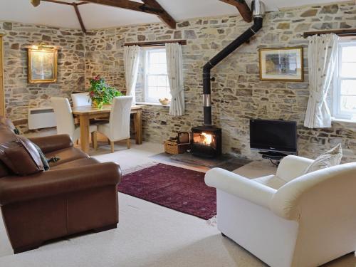a living room with a couch and a fireplace at The Coach House - 24439 in Bodmin