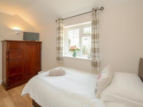 a bedroom with a white bed and a window at 1 Luckington Stables-W8321 in Holcombe