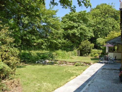 a garden with a table and chairs on the grass at The Stables in Bodmin