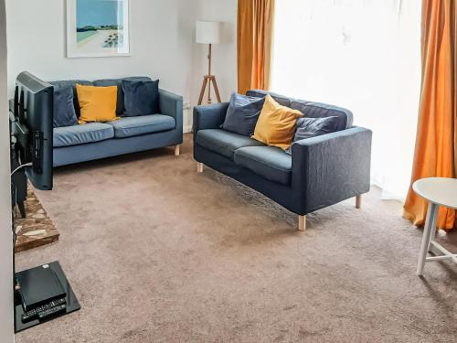 a living room with two couches and a tv at Valley Truckle Bungalow in Camelford