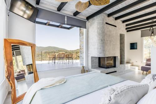 a bedroom with a large bed and a fireplace at Villa Dauti Annas in Skopelos Town