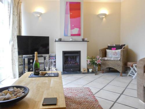 a living room with a table and a fireplace at Bellagio in Padstow