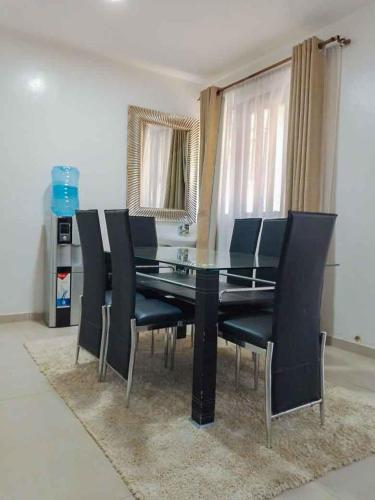a dining room with a black table and black chairs at Sofitel 3 bedrooms own compound milimani in Kisumu