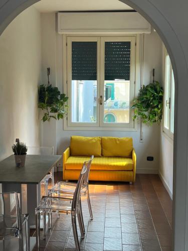 a living room with a yellow couch and a table at Matilde house in Montecatini Terme