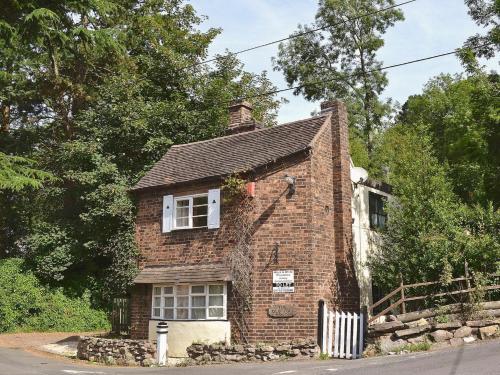an old brick house is sitting on the side of the street at The Old Toll House in Coalport