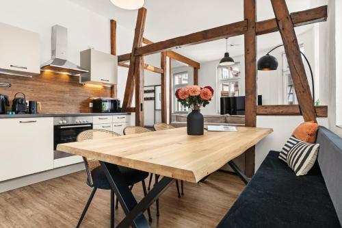 eine Küche mit einem Holztisch mit einer Blumenvase in der Unterkunft LIGHTHOUSE - Perfekt für Gruppen - 2 Whg - Zentral - PS5 & Switch in Rotenburg an der Fulda