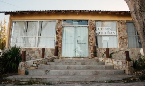 a stone building with windows and stairs in front at Tierras Blancas Nihuil in El Nihuil