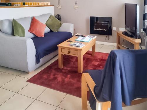 Una sala de estar con un sofá y una mesa de café. en The Cow Shed - Or5, en Henfynyw Upper