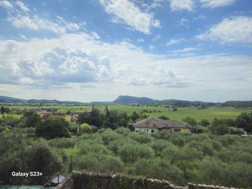 a view of a field with a house and trees at Red first floor apartment house in Costermano sul Garda