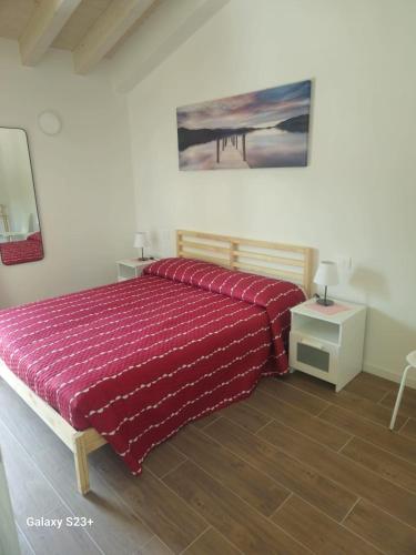 a bedroom with a bed with a red comforter at Red first floor apartment house in Costermano sul Garda