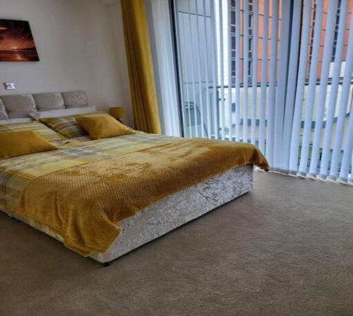 a bedroom with a large bed in a room with large windows at Stylish 2Bedroom Flat - City Centre - Near Leeds Station in Leeds