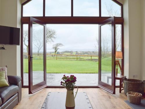 an open living room with a large glass door at Southlands Barn in Saundersfoot