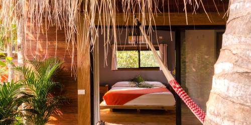 een slaapkamer met een bed en een hangmat in een kamer bij Hotel Noga in Zipolite