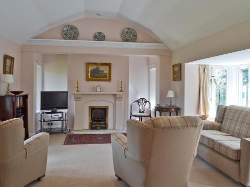un salon avec deux canapés et une cheminée dans l'établissement Stable Cottage, à Lyminster