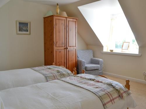 a bedroom with a bed and a cabinet and a chair at Prospecthill House in Whitehouse
