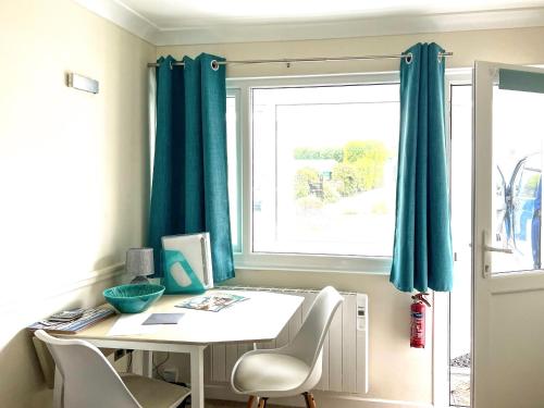 a room with a table and chairs and a window at Puffins in Port Isaac